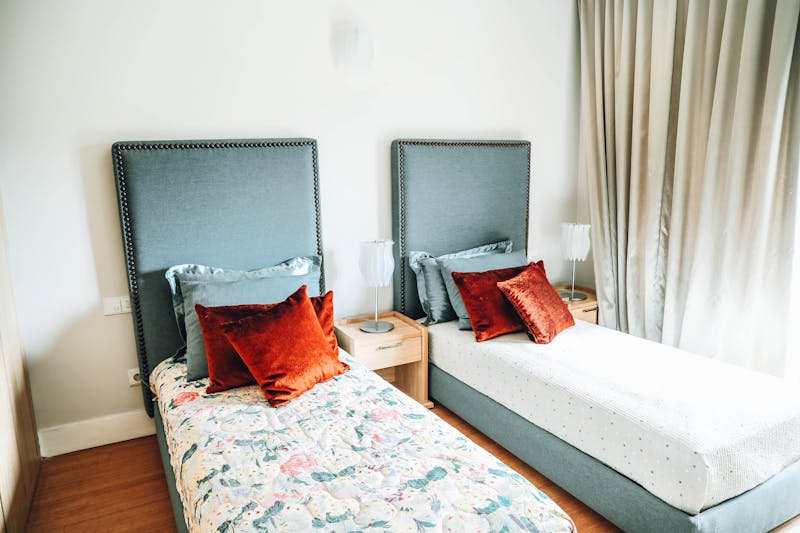 Dwa jednoosobowe łóżka w pokoju hotelowym